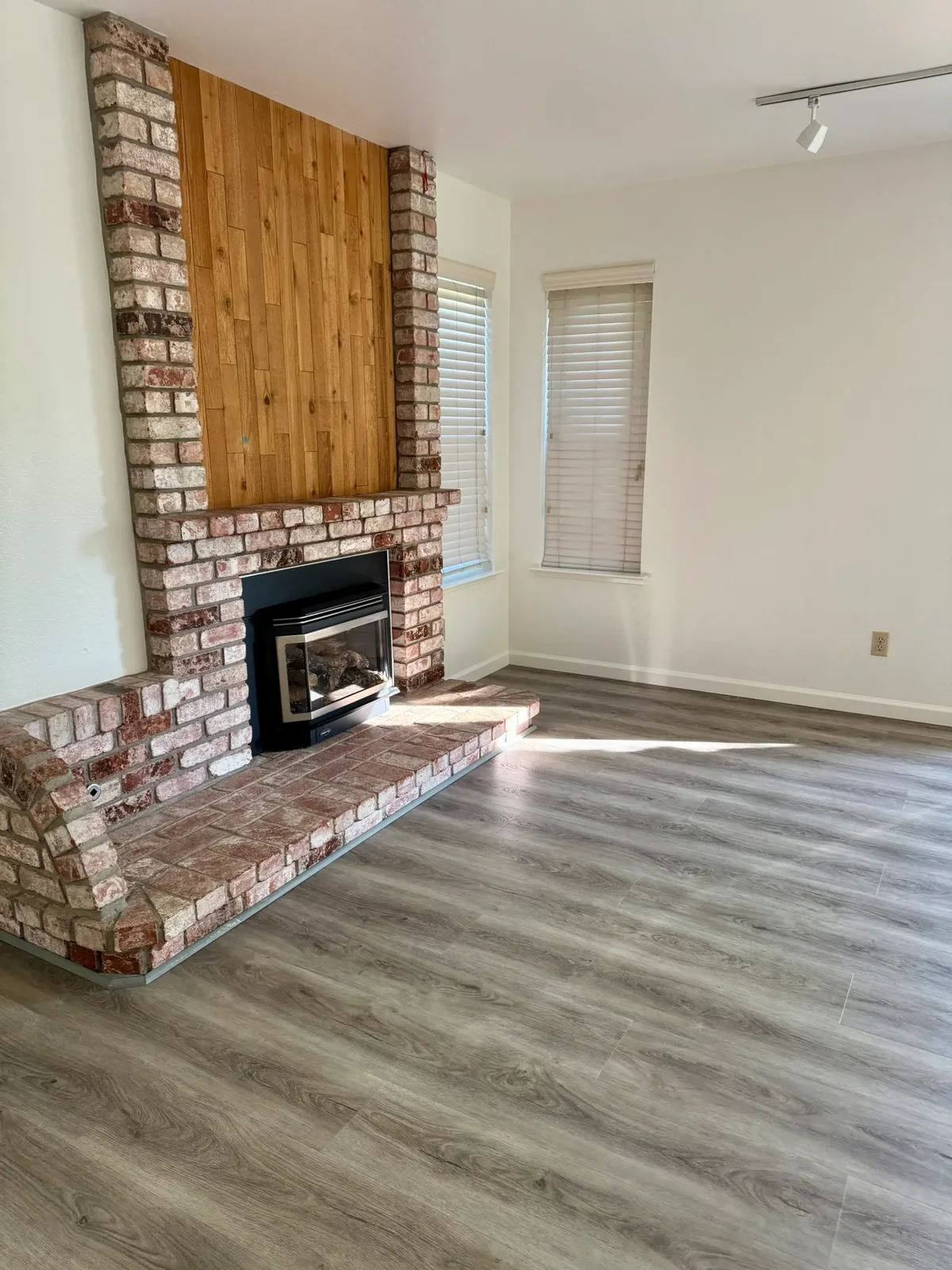 Living room with brick fireplace, floors cleaned